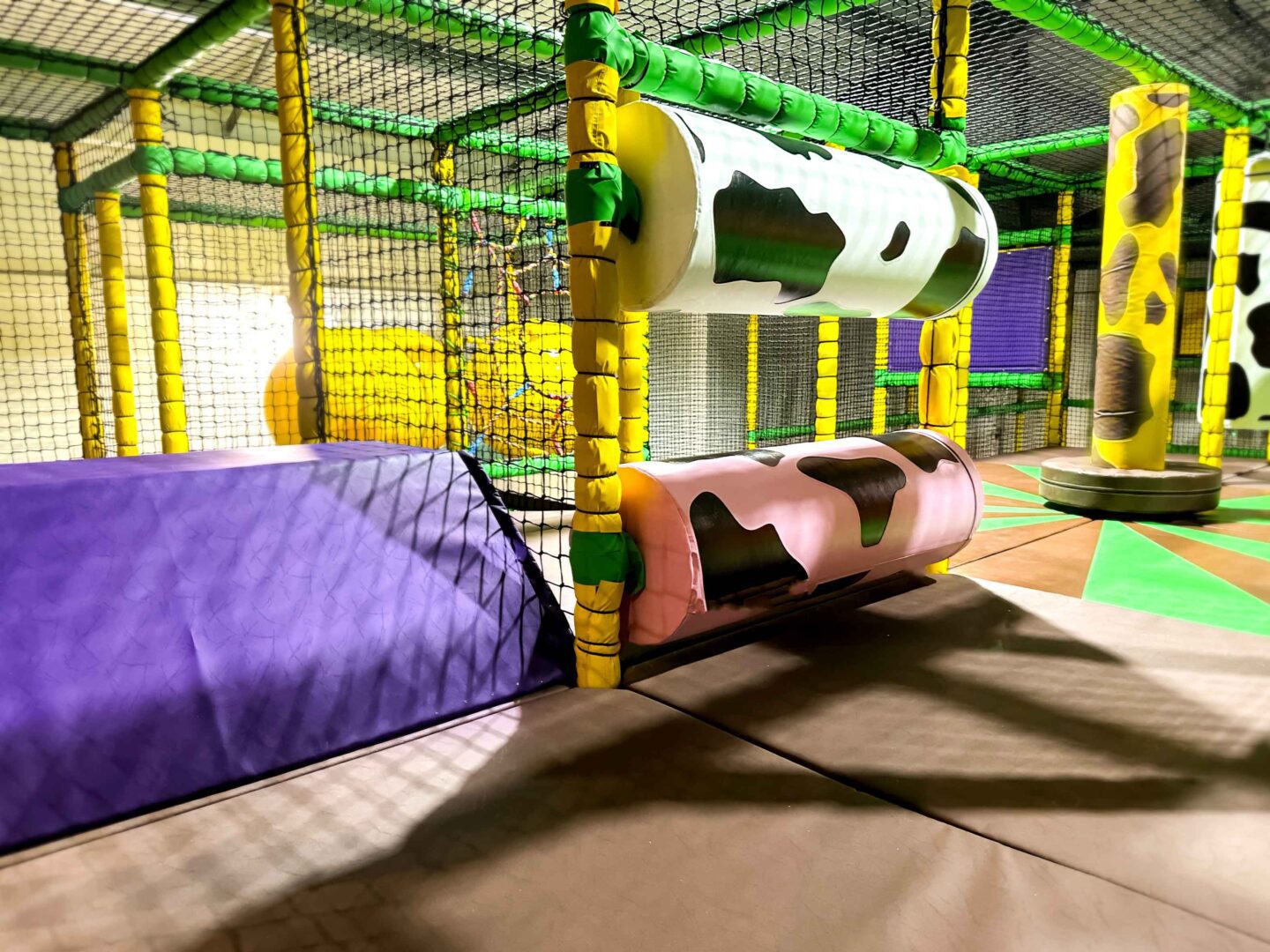 Cannon Hall Farm's Custom-desinged Horizontal Rollers featuring a white and pink one with a cow-print design. There's also a yellow print dizzy disk and purple wedge block. These were all designed and manufactured by Play Creations.