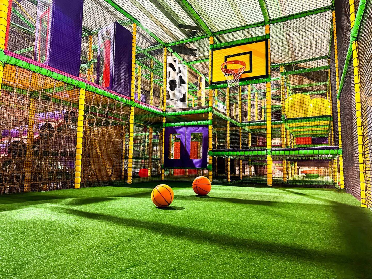 Large sports area at Cannon Hall Farm's indoor softplay. This features 2 basketball nets with astro turf flooring. This area was designed by Play Creations.