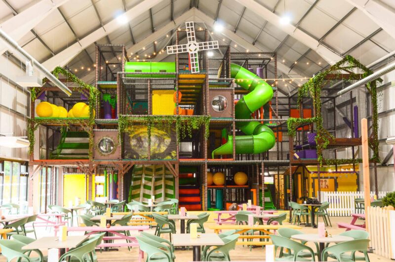 Brocksbushes Farm's Multi-level softplay, featuring a rustic farm theme. The softplay is brown green and orange and features a green tube slide and a seperate role-play area. Designed by Play Creations.