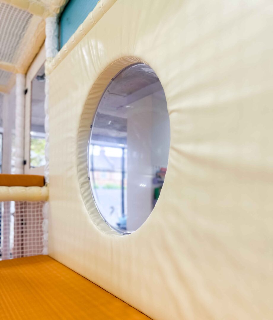 Bubble Window encased in cream vinyl at It Takes a Village's indoor softplay area designed by Play Creations