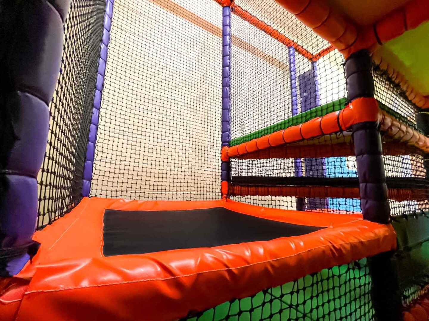Corner Climb and Trampoline. Orange purple and green theme at St Giles Schools indoor softplay area for SEND kids.