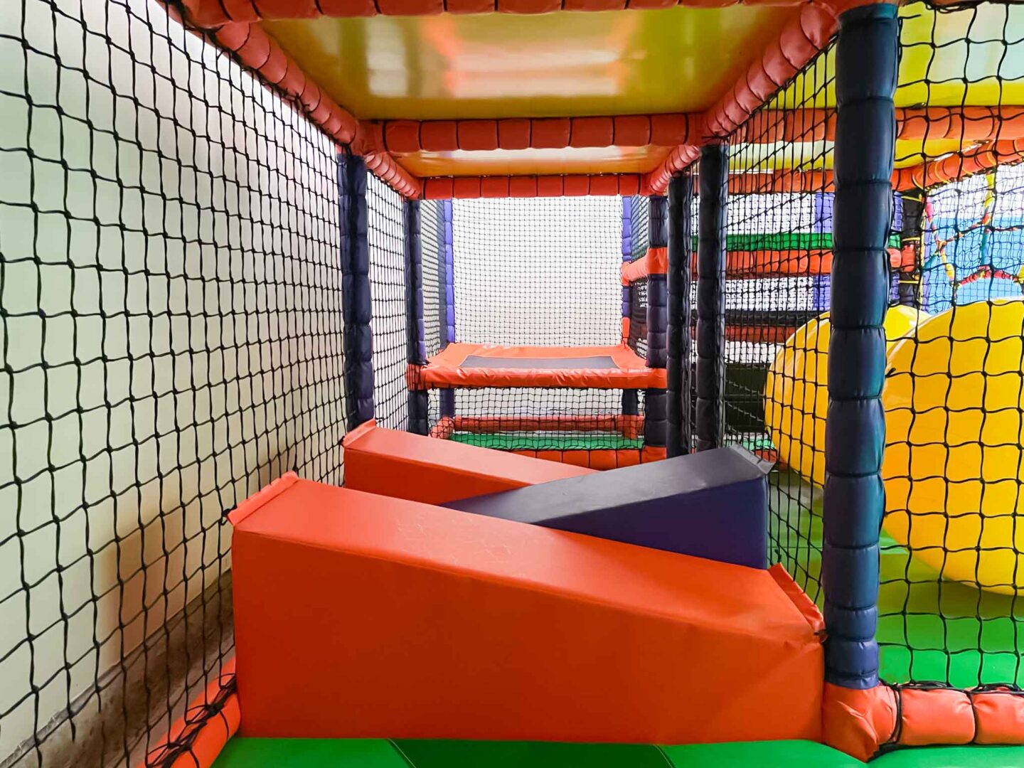 Orange and purple wedge floor corridor at St Giles indoor softplay area designed by Play Creations.