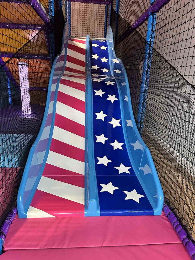 Stars and Stripes themed Twin Lane Wavy Slide found at RAF Lakenheath's softplay designed and manufactured by Play Creations Ltd.