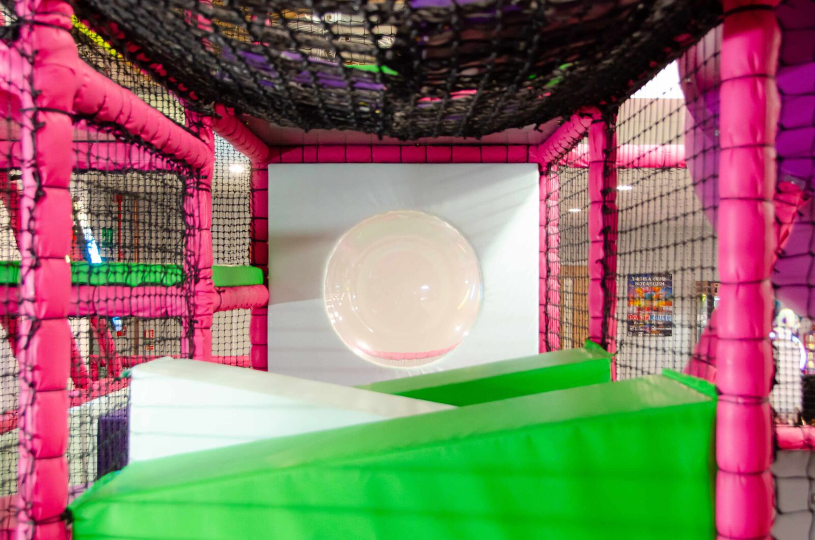 This is the wedge floor into Dome Window found at the toddler area at Fun Factory's indoor softplay area. The theme for this image is pink, green and white.